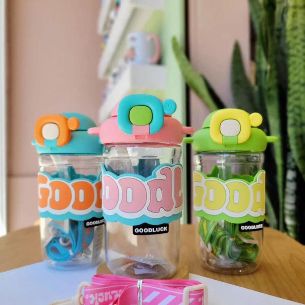 Three colorful water bottles with 'GOODLUCK' branding on a wooden surface.